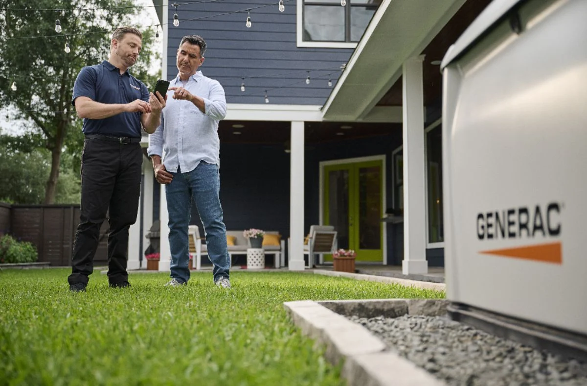 A Louisville homeowner standing with a Varitech generator installation specialist learning about ATS systems & remote monitoring
